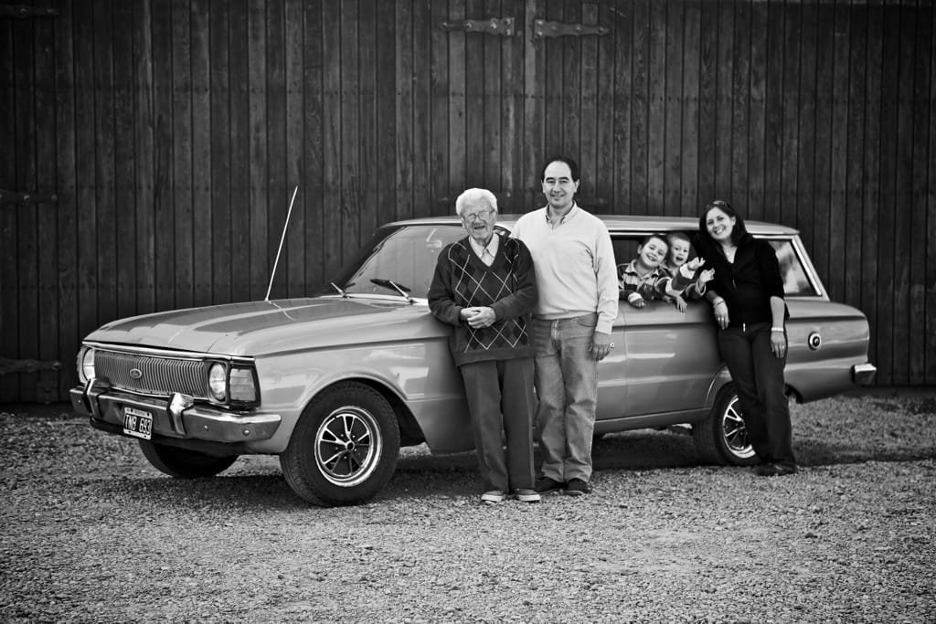 The Cecchin family standing beside a vintage car